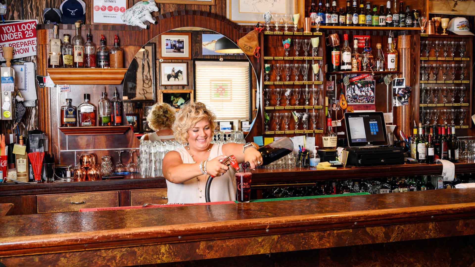 Bartender pouring drink in a saloon.